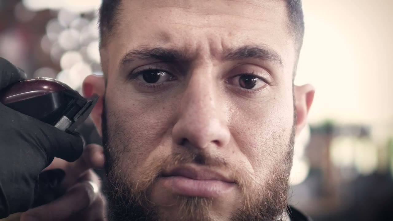Client having his sideburn trimmed with clippers