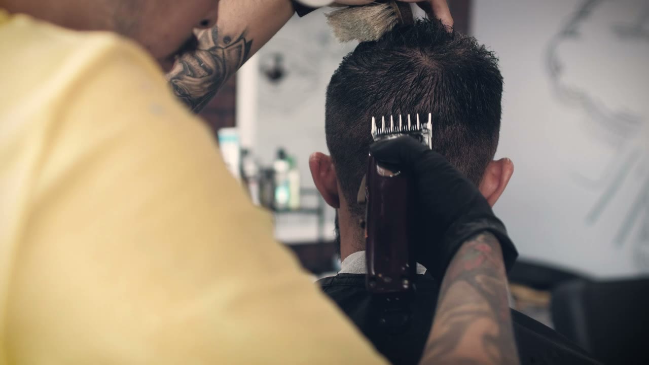 Barber fading the back of a client's head with a guard clipper